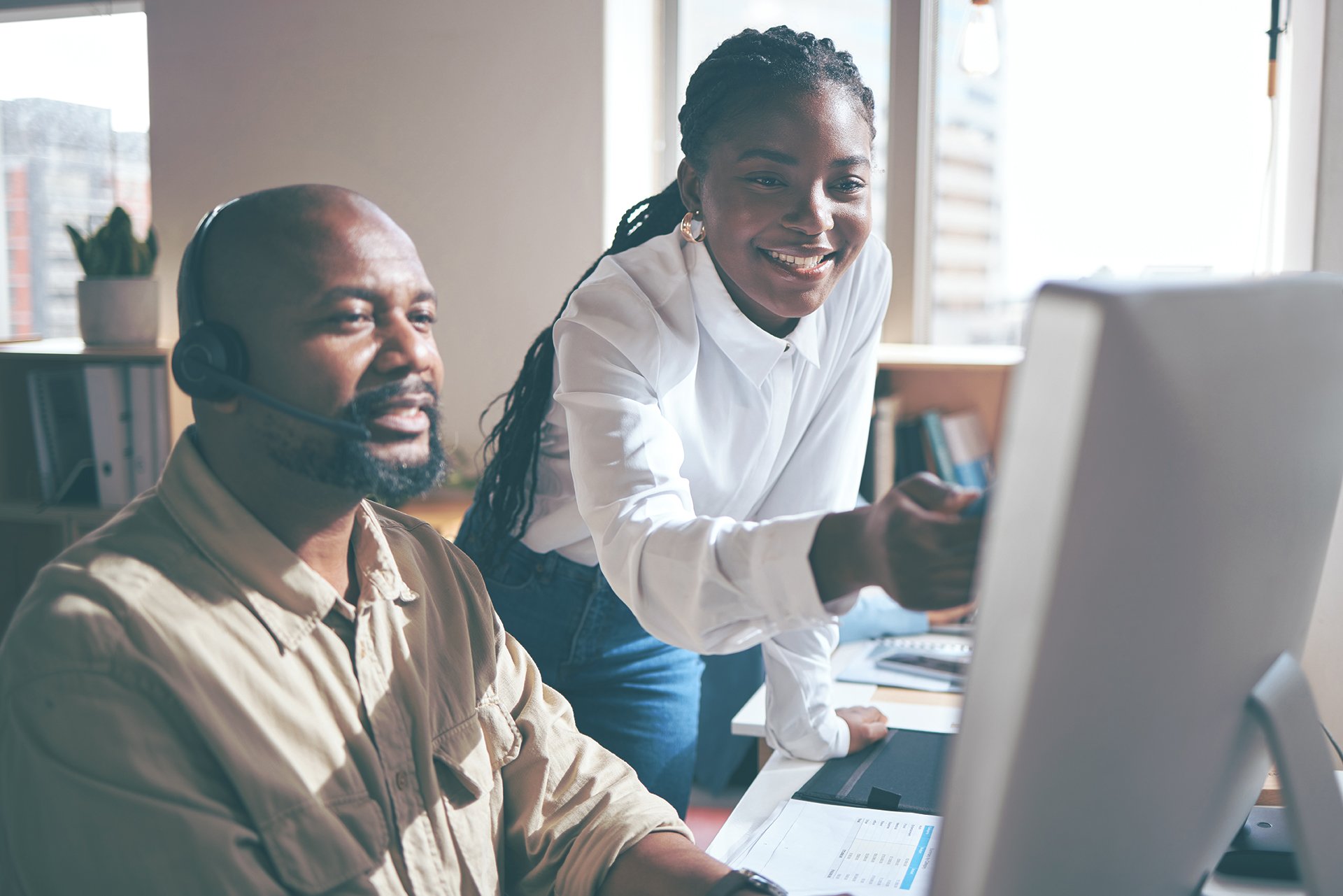 A man look at a screen while a woman points to the screen