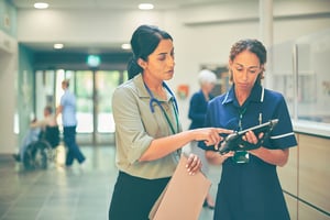 Two NHS professionals reviewing patient records